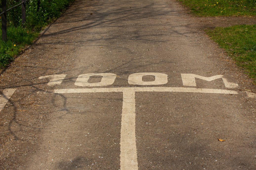 White lines and 100 meter marking painted on the asphalt of a road